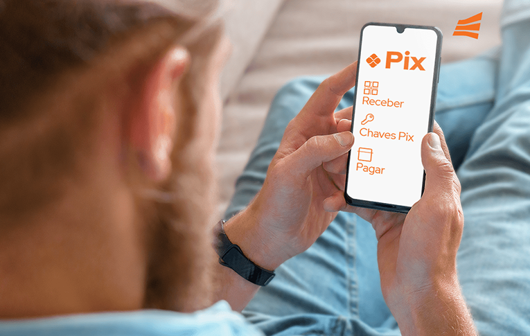 Na imagem: lateral do rosto de um homem. Ele segura um aparlho celular nas mãos e na tela aparece em laranja o logo do Pix, e as oções "Chave Pix", "Enviar um Pix" e "Receber um Pix"