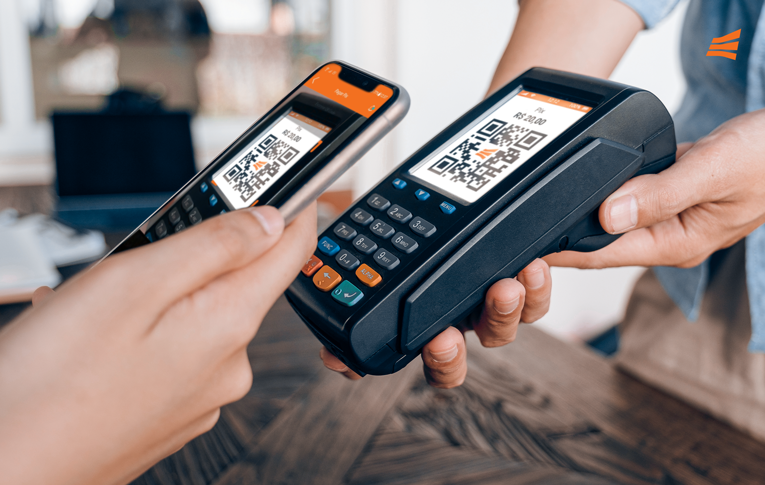Cliente realizando pagamento de uma compra pelo celular, com leitura de QR Code, na maquininha de cartão.