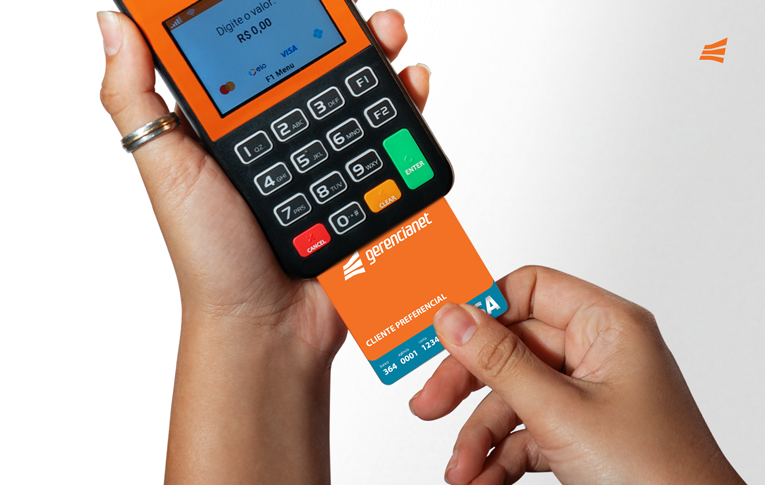 Mãos segurando uma maquininha de cartão e inserindo o cartão de crédito pré-pago da Gerencianet.
